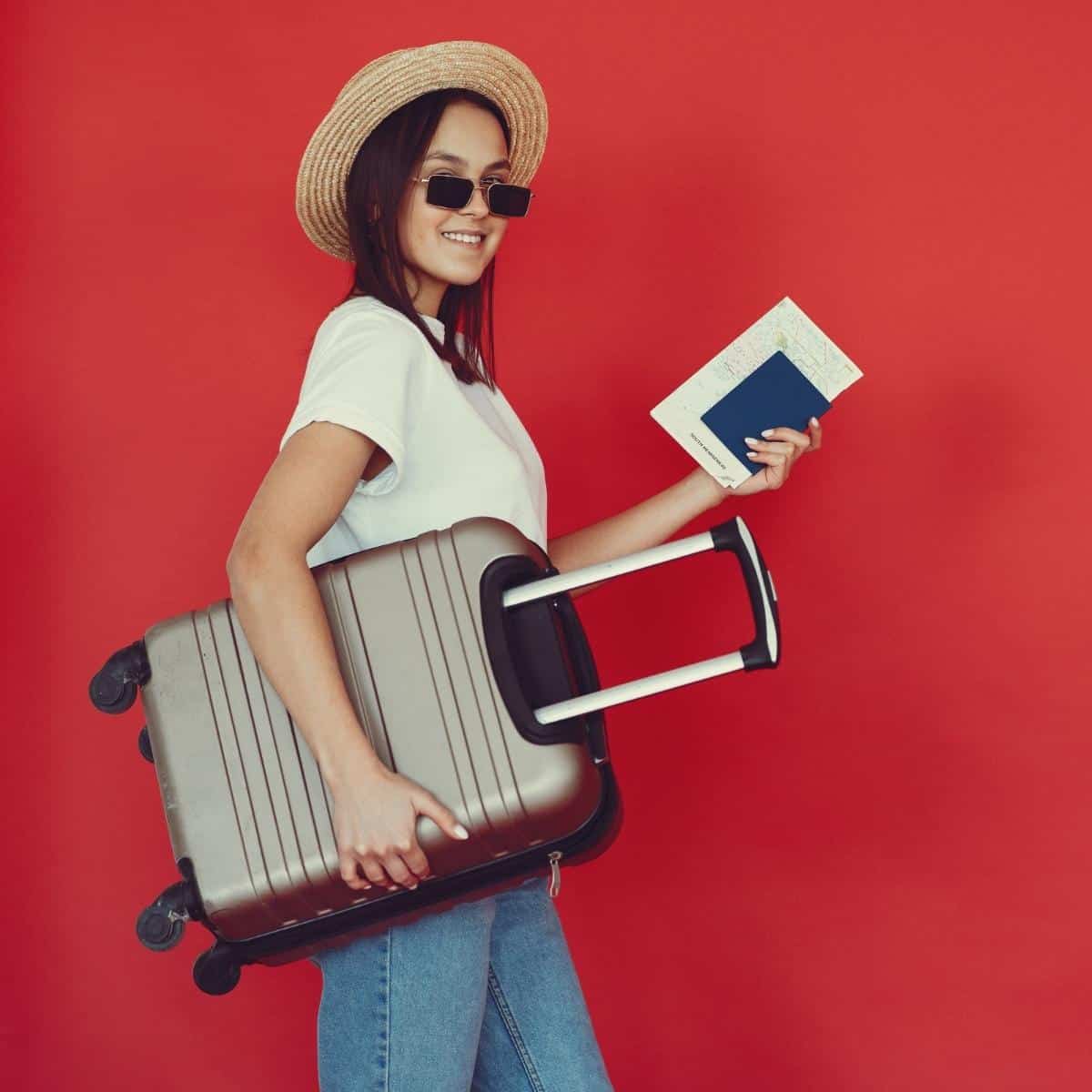 Lady with suitcase on holiday with passport and tickets in her hand