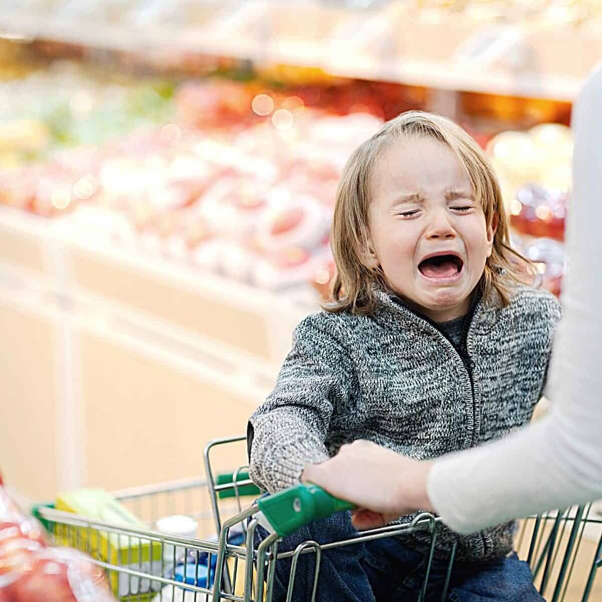 child crying in supermarket trolley