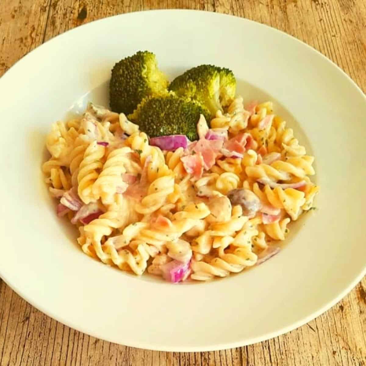 Cheese and ham pasta served with broccoli