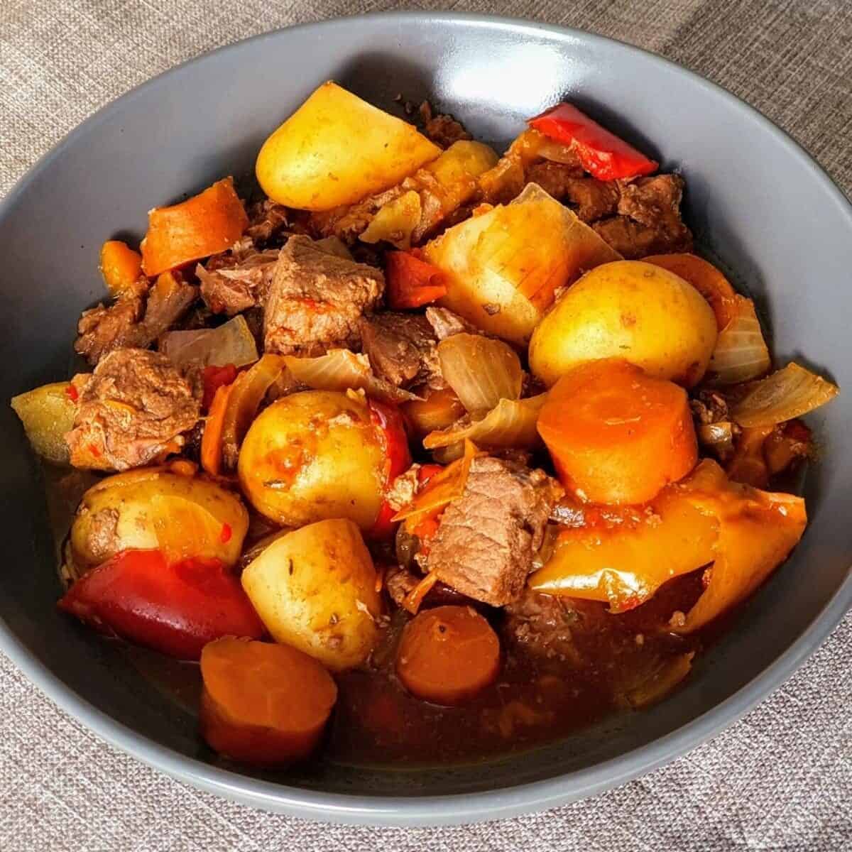 Closeup of Jamaican beef stew in black bowl