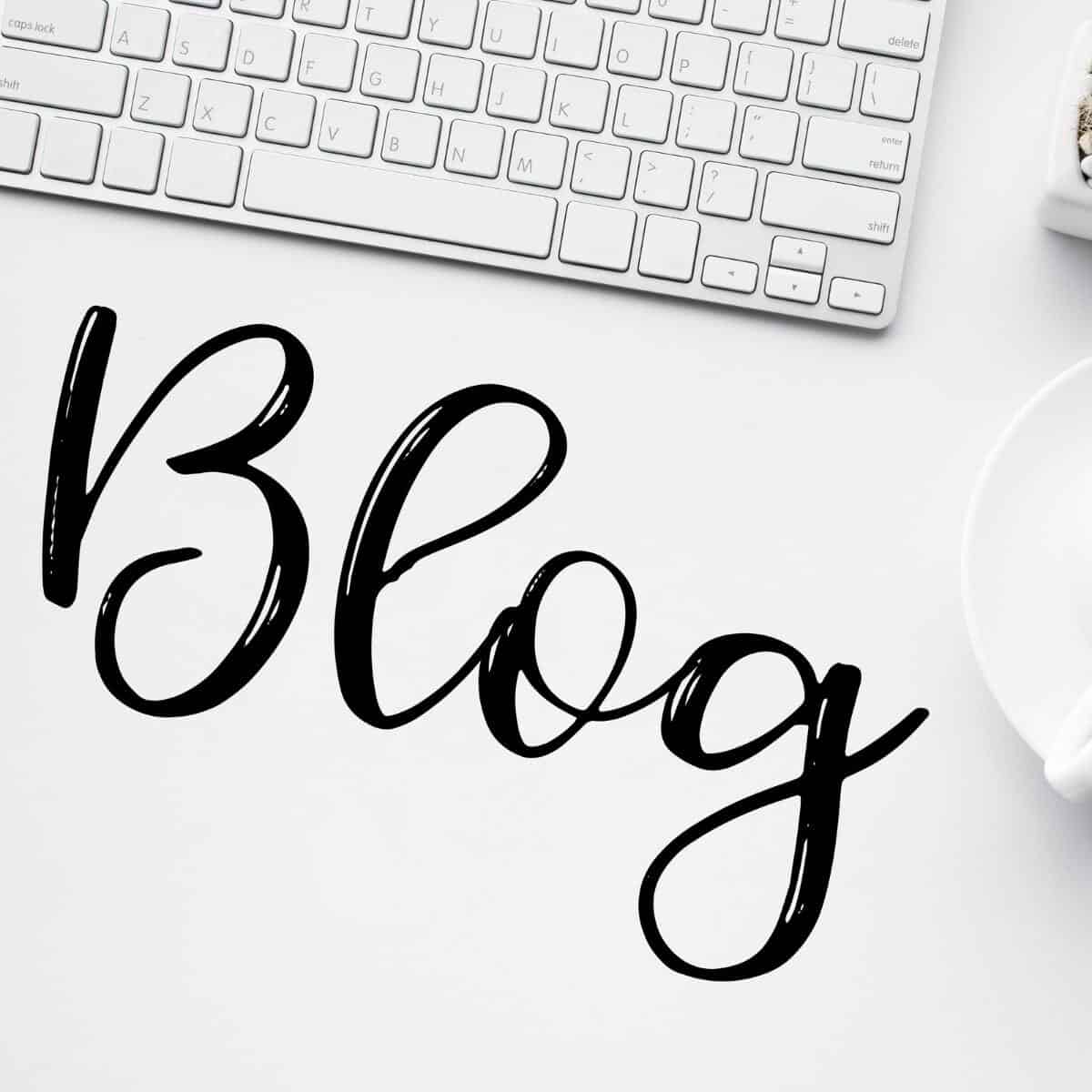 Blog written on a white desk next to a laptop keyboard