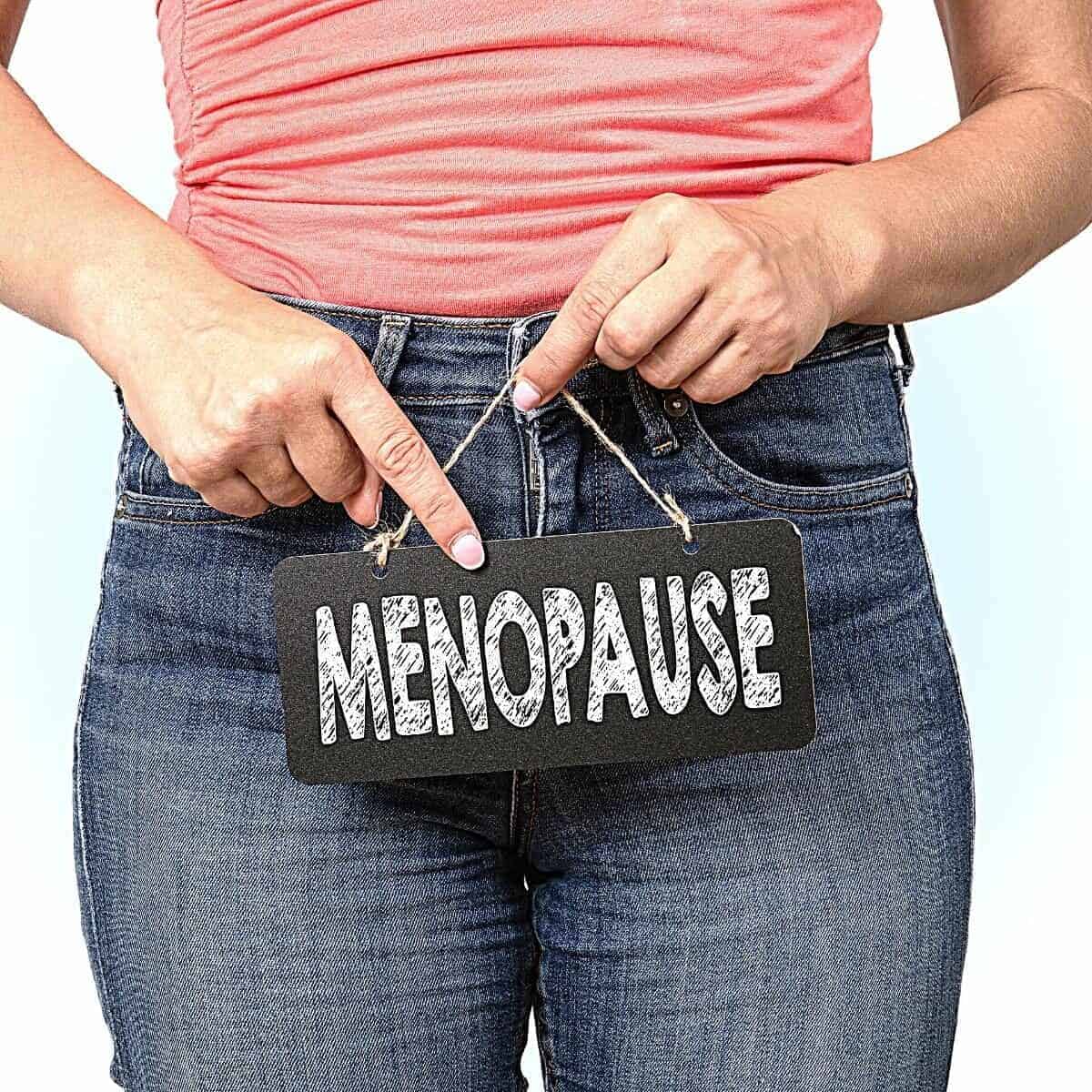 A lady holding a sign saying menopause
