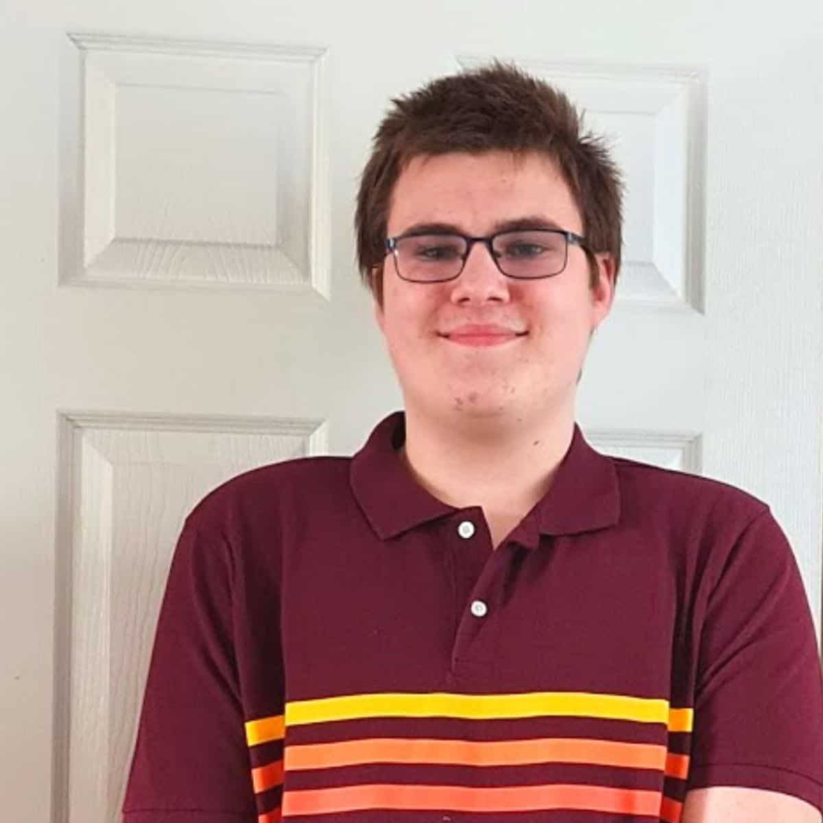 Teenage boy wearing a red top and smiling