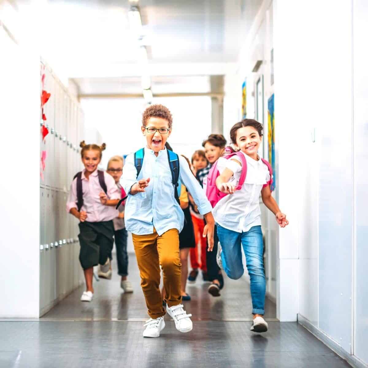 children runnin in a school coridoor smiling happily