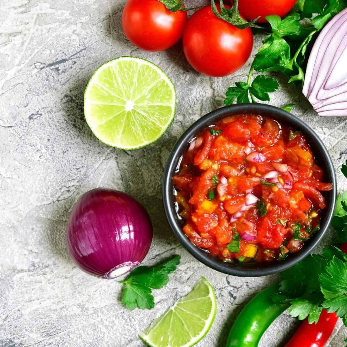 chilli salsa in a bowl with ingredients around it