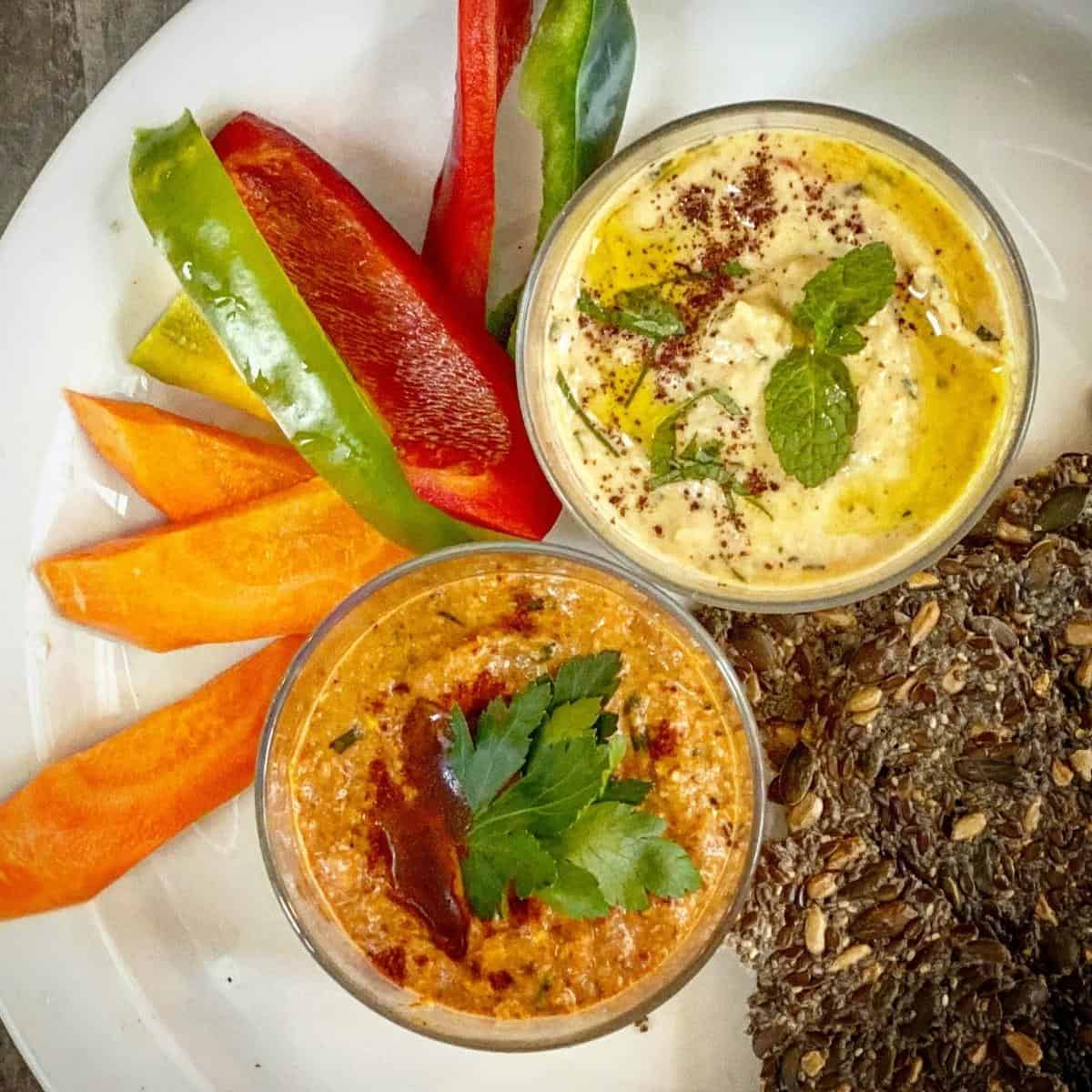 vegan red pepper dip with another dip and veg sticks