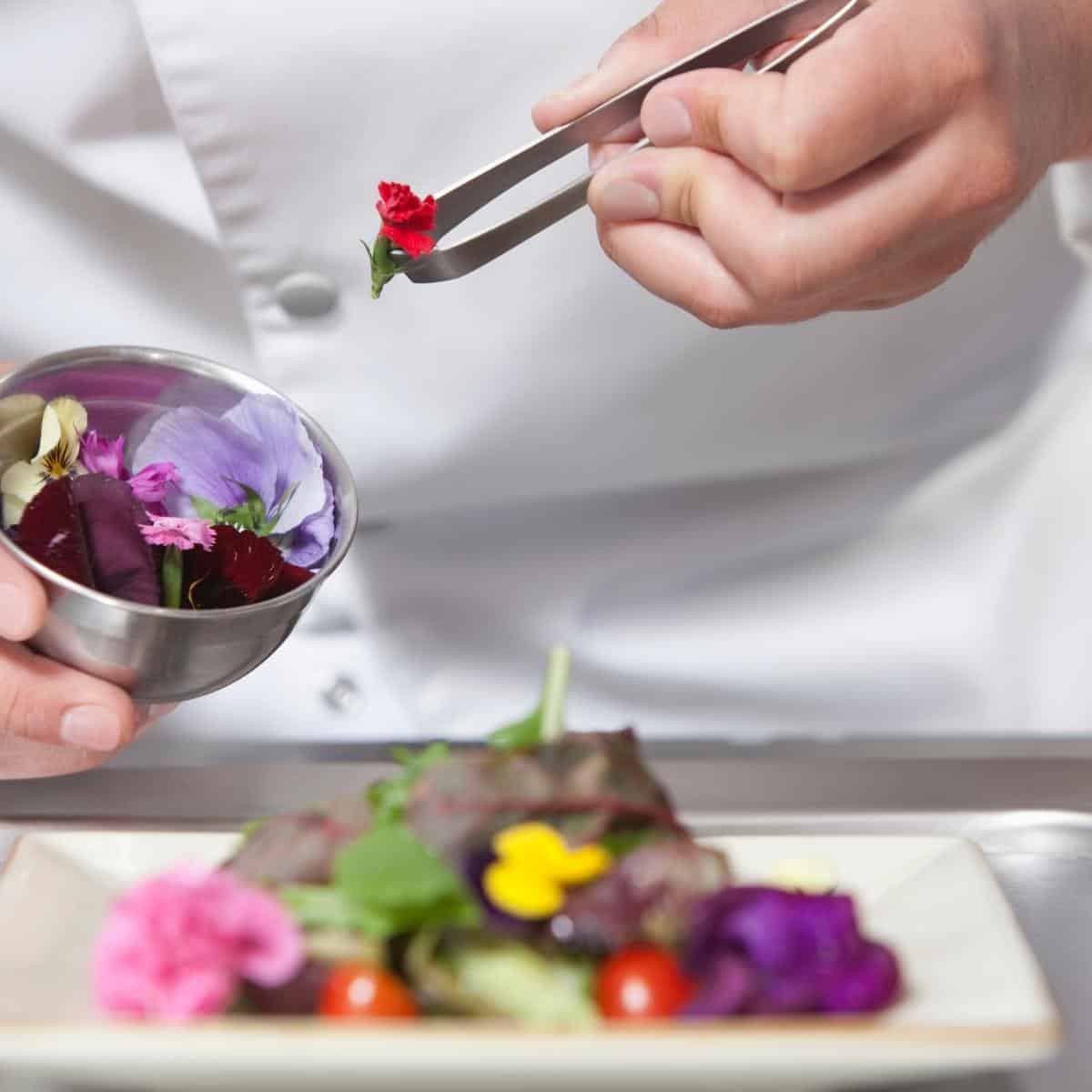 edible flowers being added to a dish