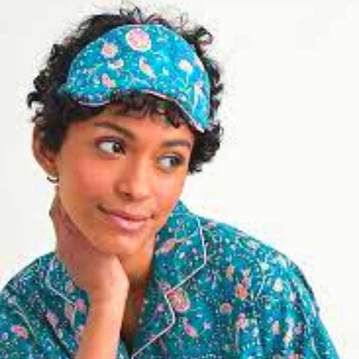 a woman wearing a blue pajamas and a sleeping mask