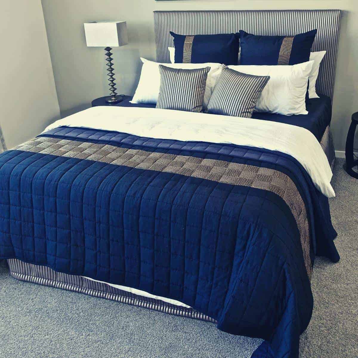 navy coloured bedding on a double bed in tidy bedroom
