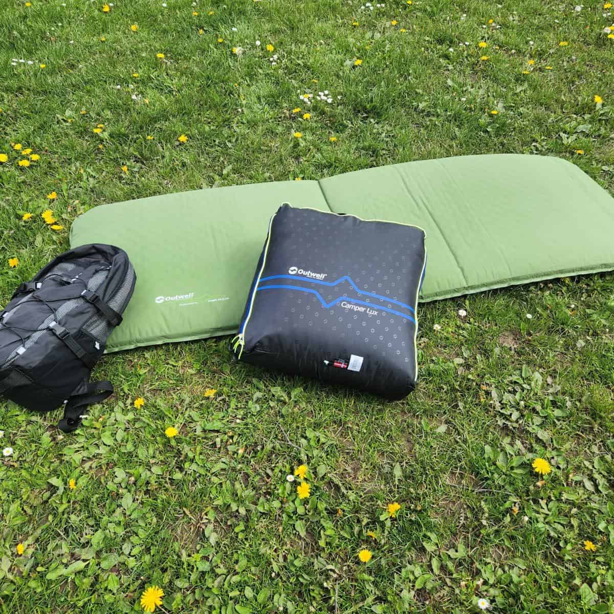 camping mat, sleeping bag and rucksack on grass