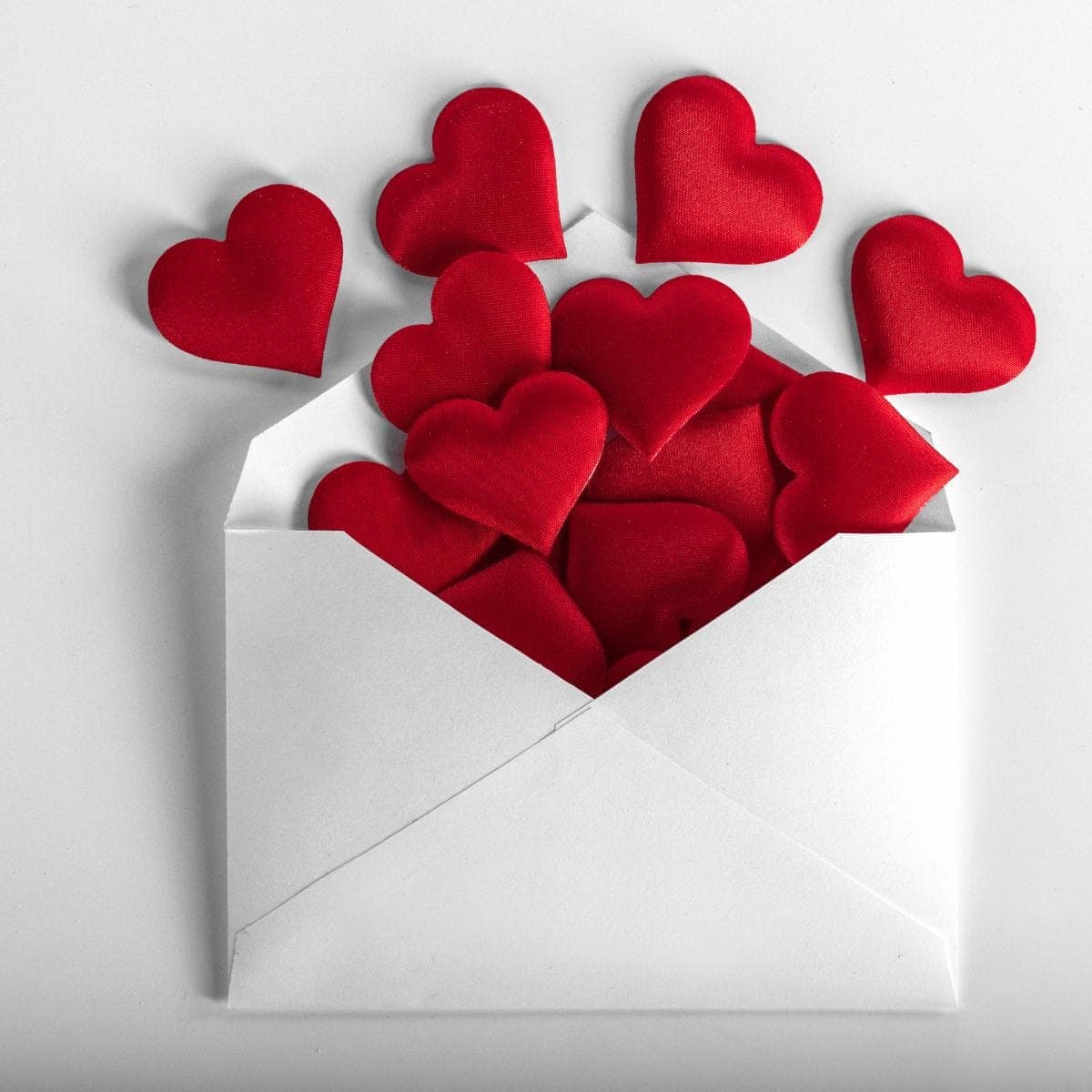 an envelope containing heart shaped red shapes.