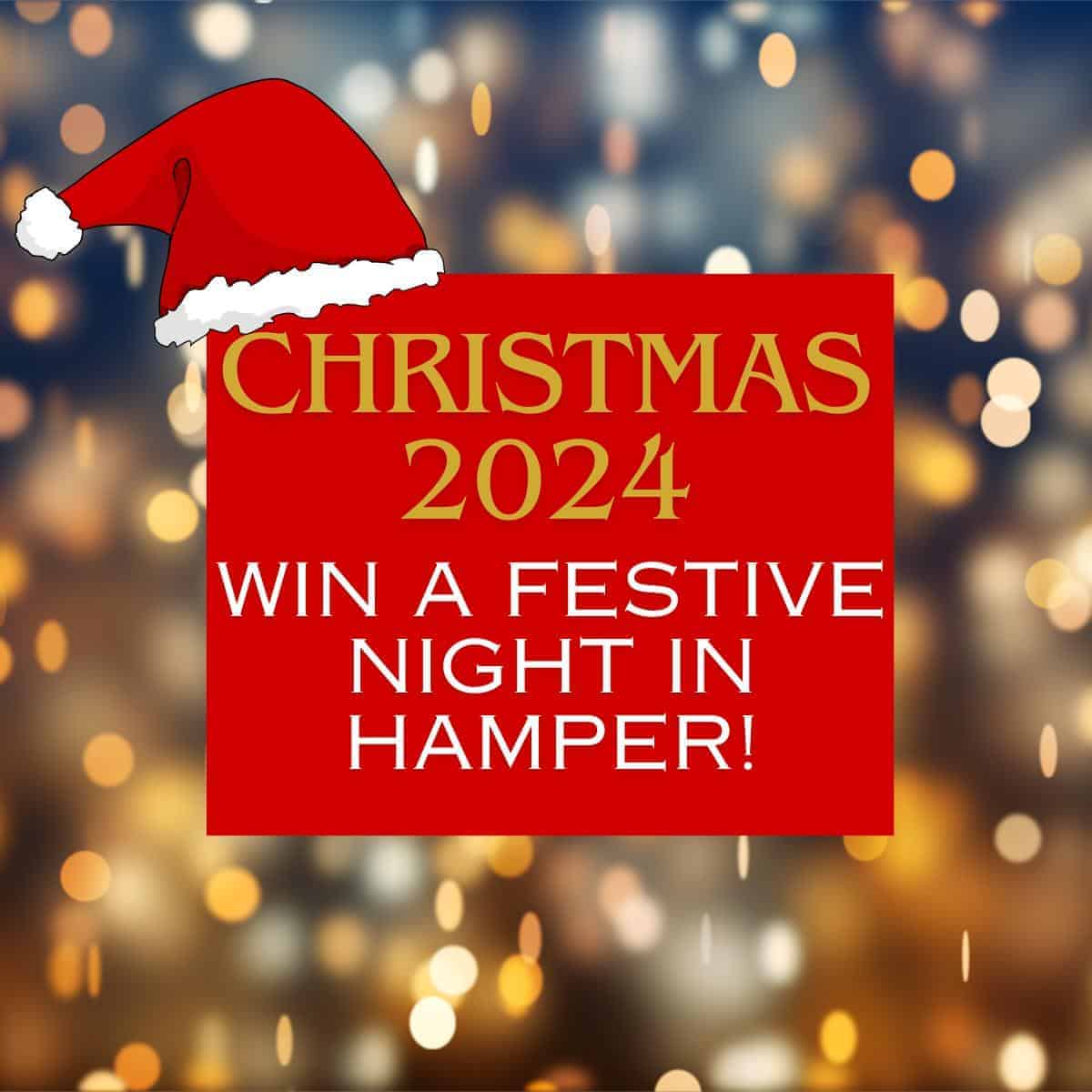 Festive graphic with blurred lights background, red hat on top. Text: "Christmas 2024, Win a Cozy Night In Hamper!.