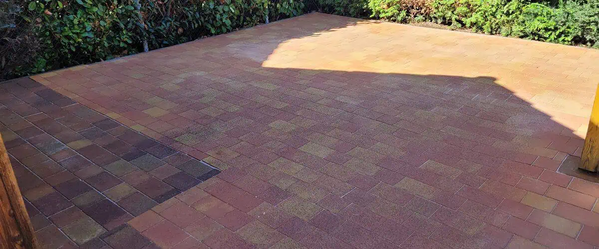 Gereinigte Pflasterfläche: Vorher-Nachher Effekt auf einer Terrasse. Professionelle Reinigung für ein sauberes Zuhause.