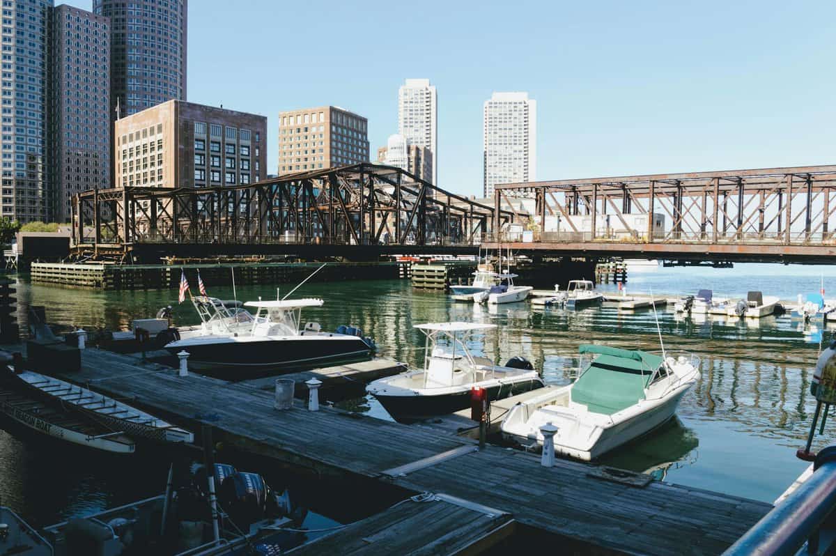 several boats on body of water under brown bridge