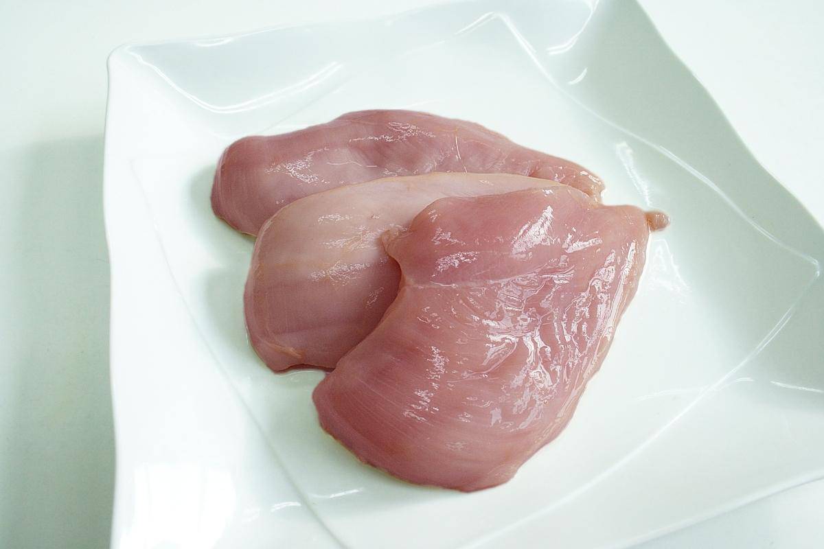 raw chicken breasts on a white plate