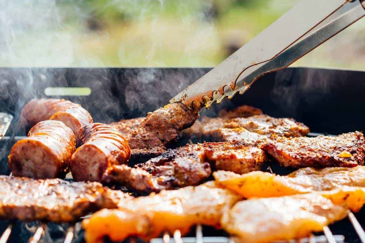 bbq with tongs turning over meat.