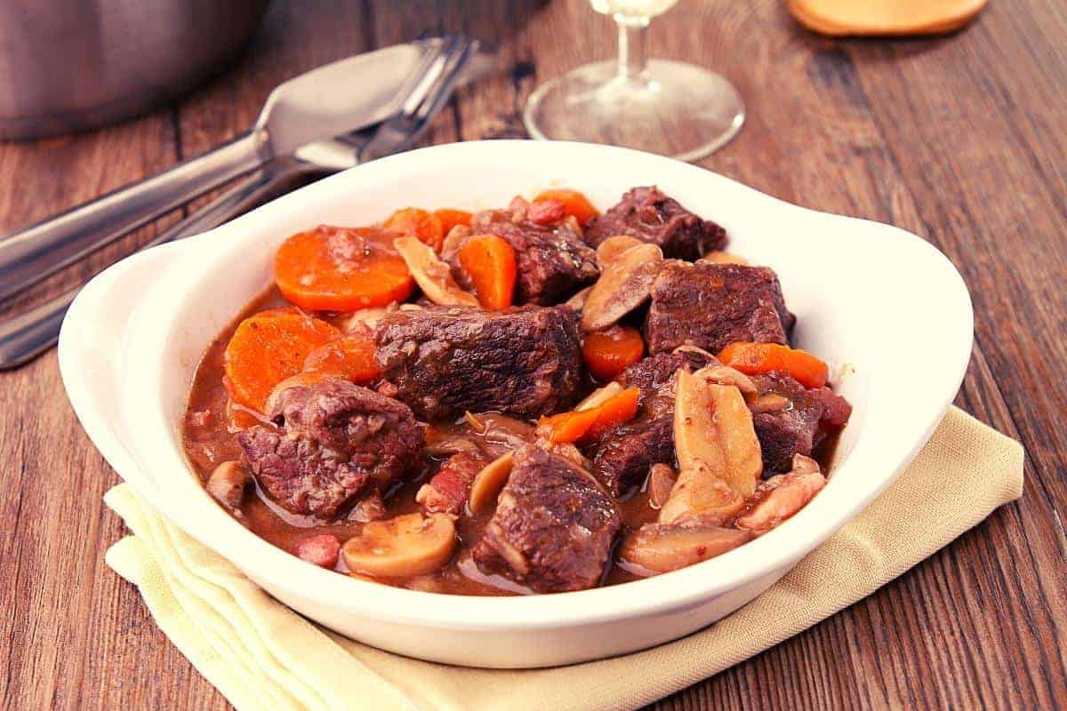 Beef bourguignon with chunks of beef, carrots and mushrooms in a gravy type sauce.