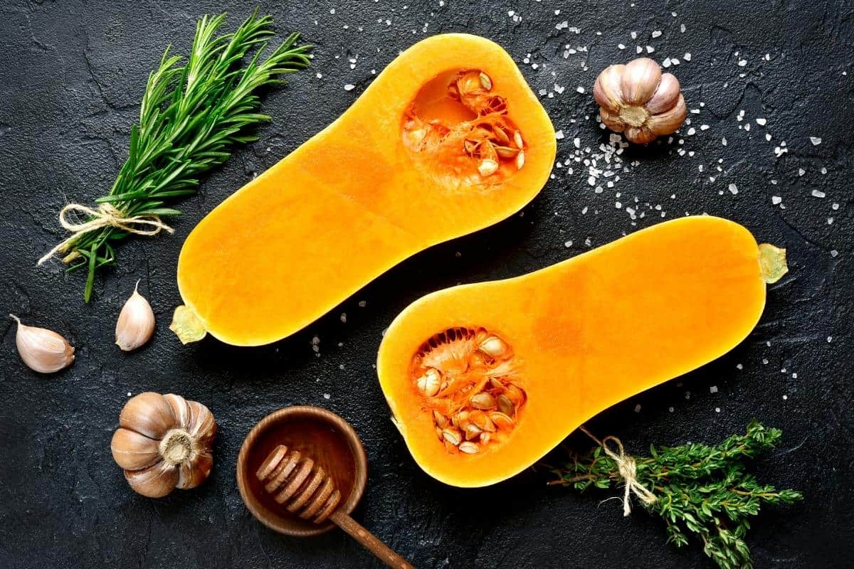 butternut squash cut in half on a dark surface