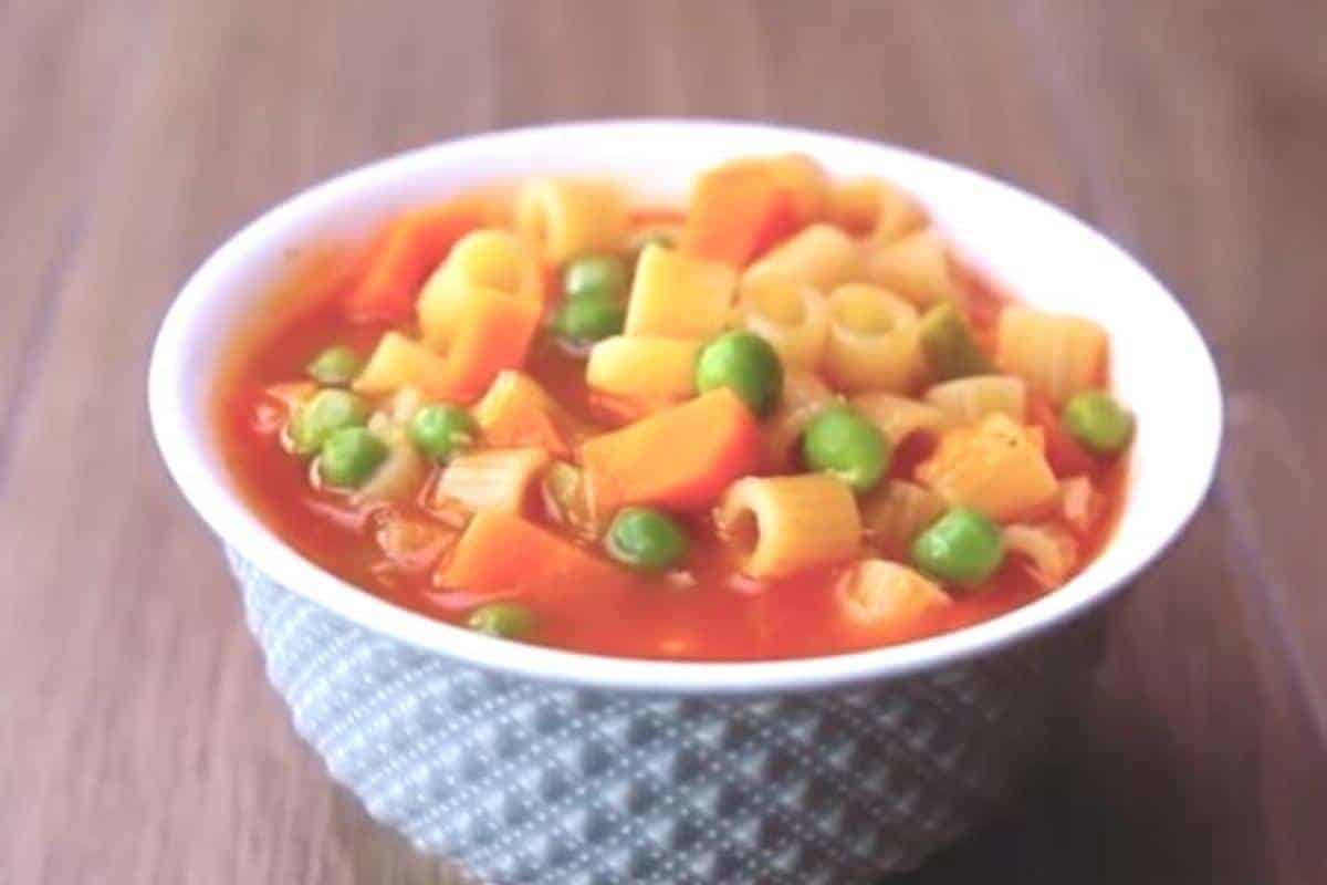 Pasta soup with small pasta tubes, peas and a tomato sauce.