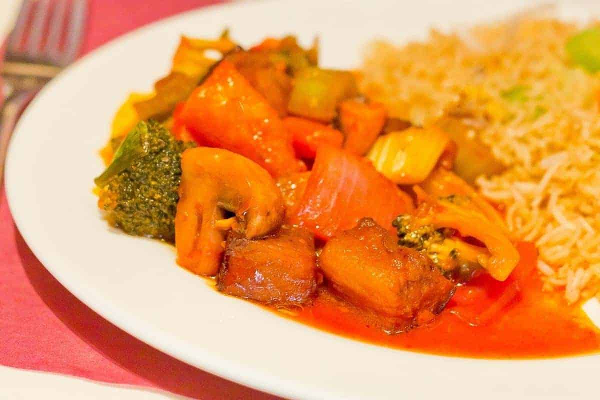 Sweet and sour vegetables on a white plate with rice