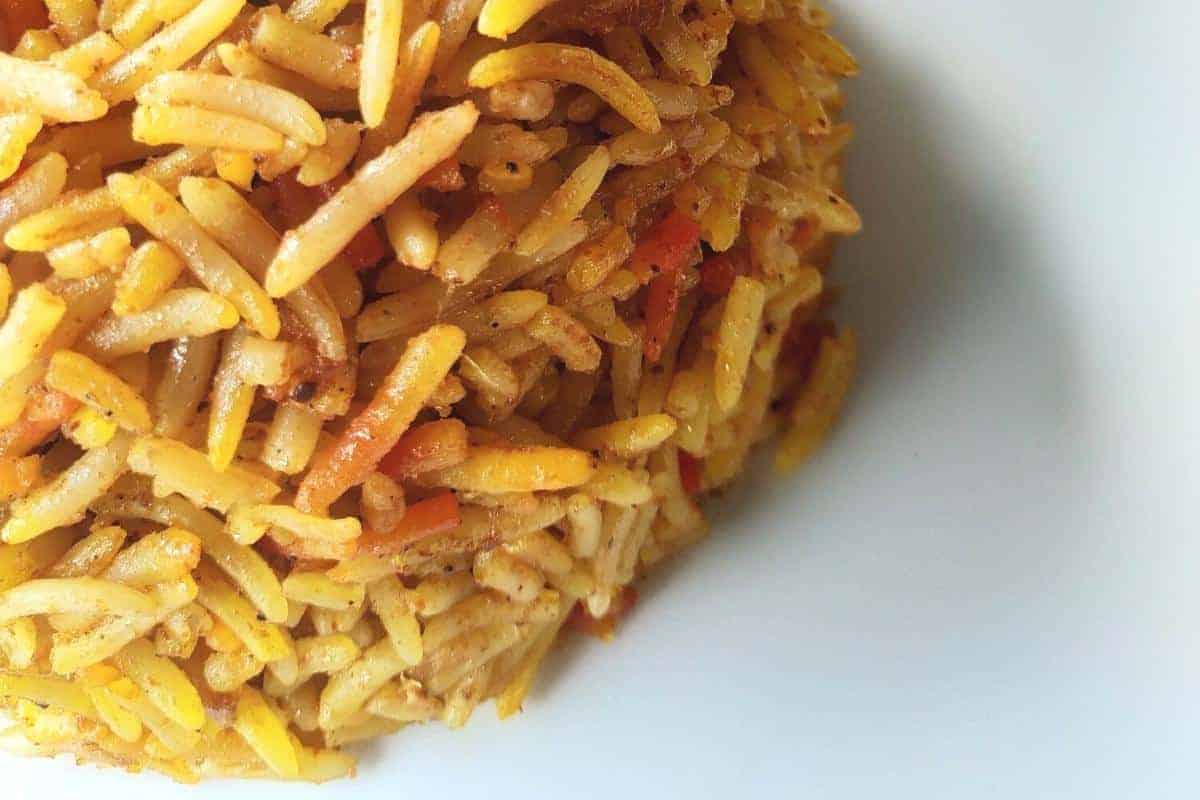 Mixed vegetable biryani with rice in shades of yellow and grey.