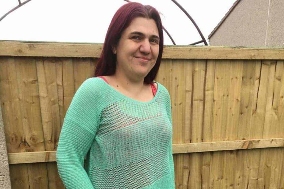 Jen with green top and straight brown hair coloured with a hint of red or dark purple.