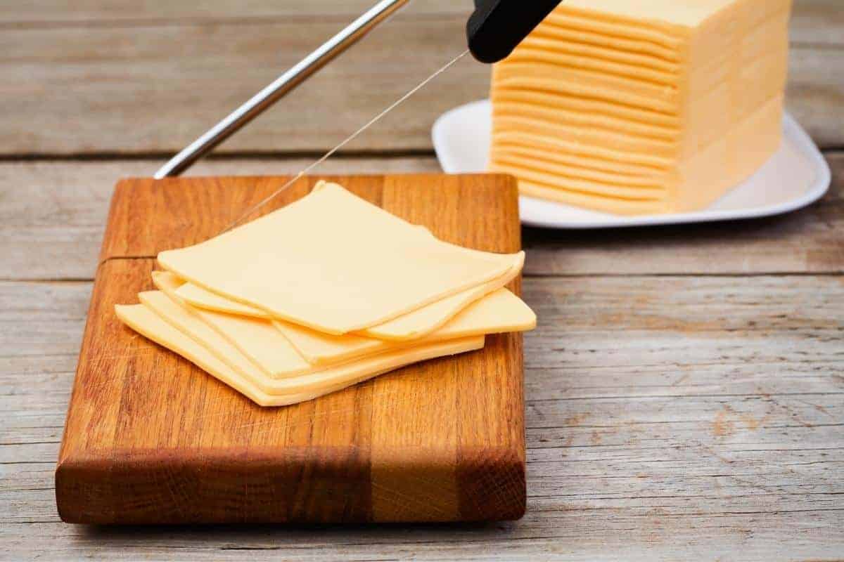 Cheese slices on a wooden block.