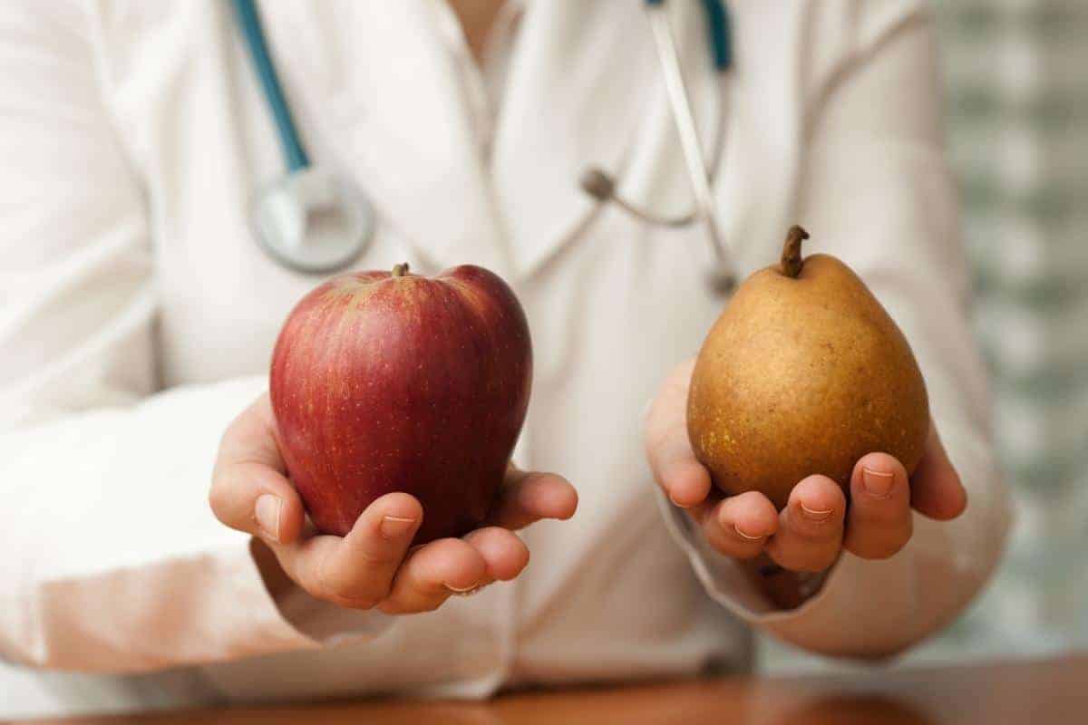 a doctor holding an apple in one hand and a pear in the other