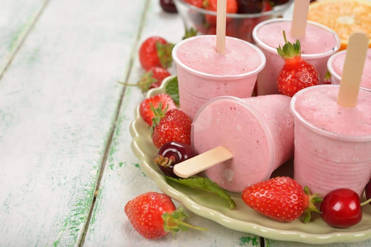 a plate of popsicles with strawberries on them