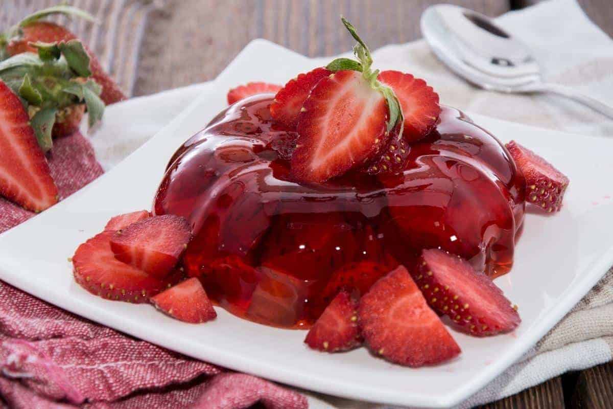 White square plate with jelly and strawberries