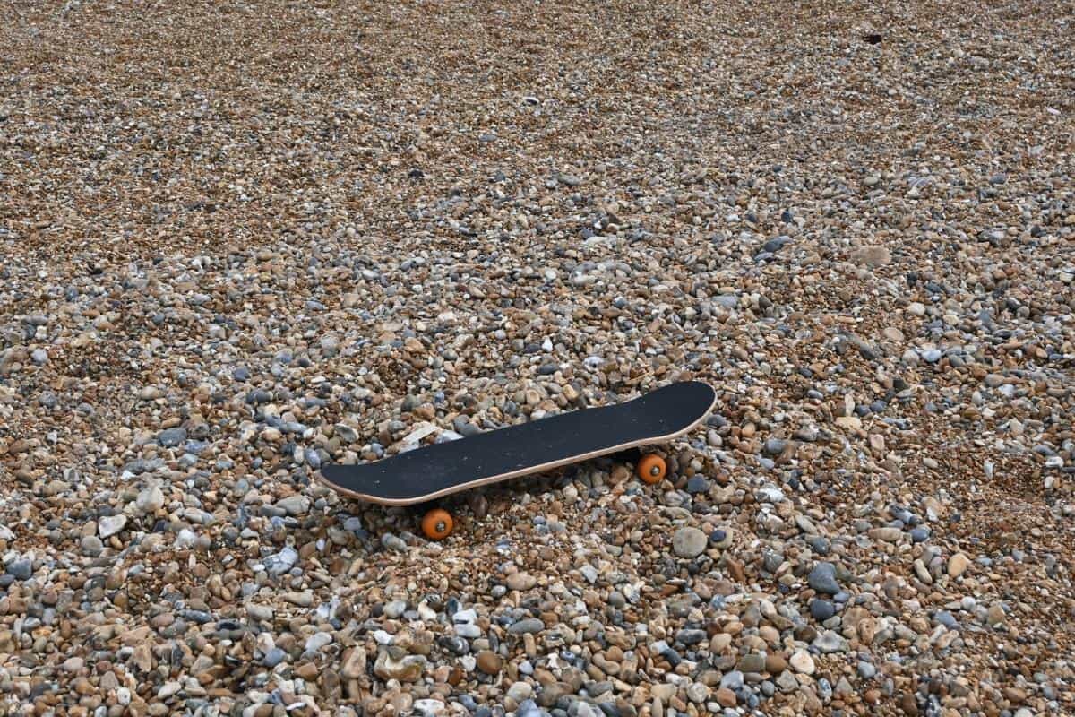 skateboard on a pebble beach.