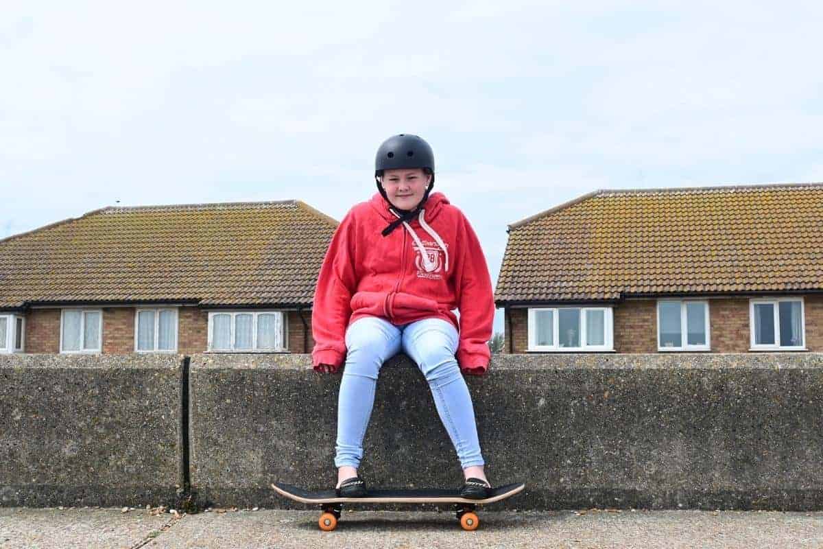 teenage girl skateboarding on concrete on the beach front.