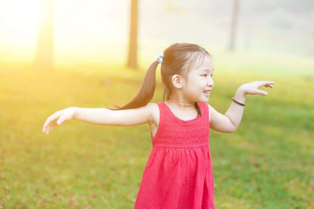 young girl dancing on grass
