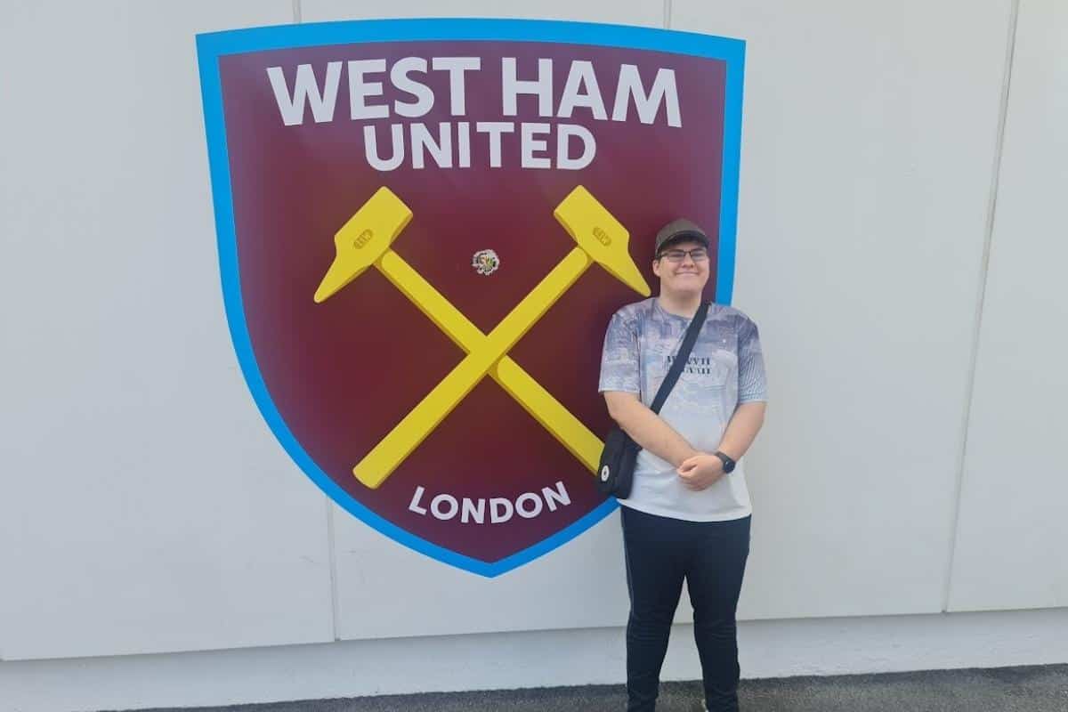 a man standing in front of West Ham United badge