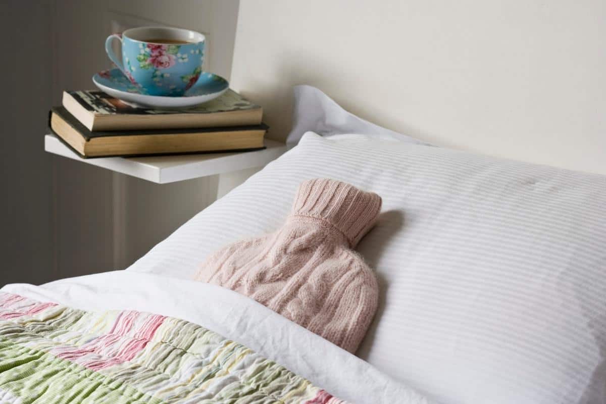 Hot water bottle tucked into a bed.