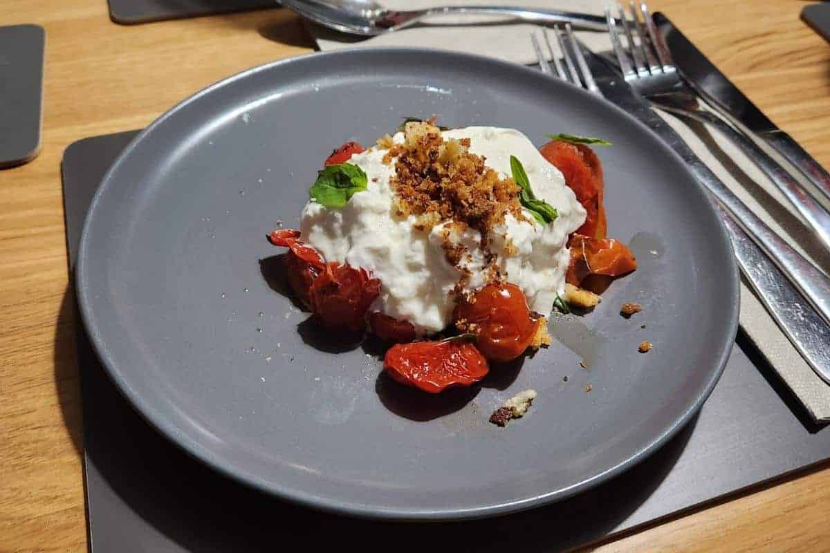 Burrata with burst deterini tomatoes, basil and penagrato