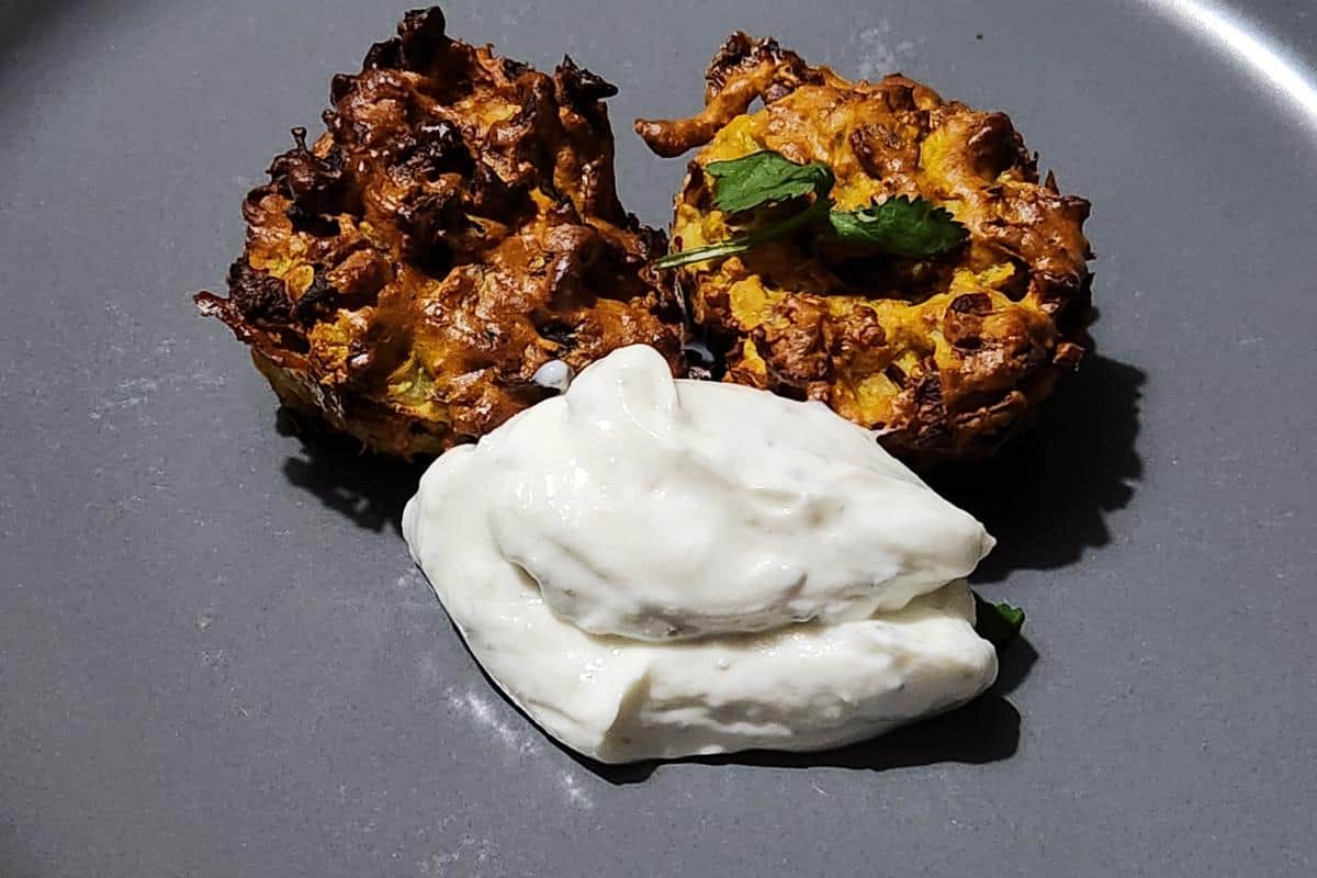 healthy air fryer onion bhajis on a plate with mint and yoghurt dip