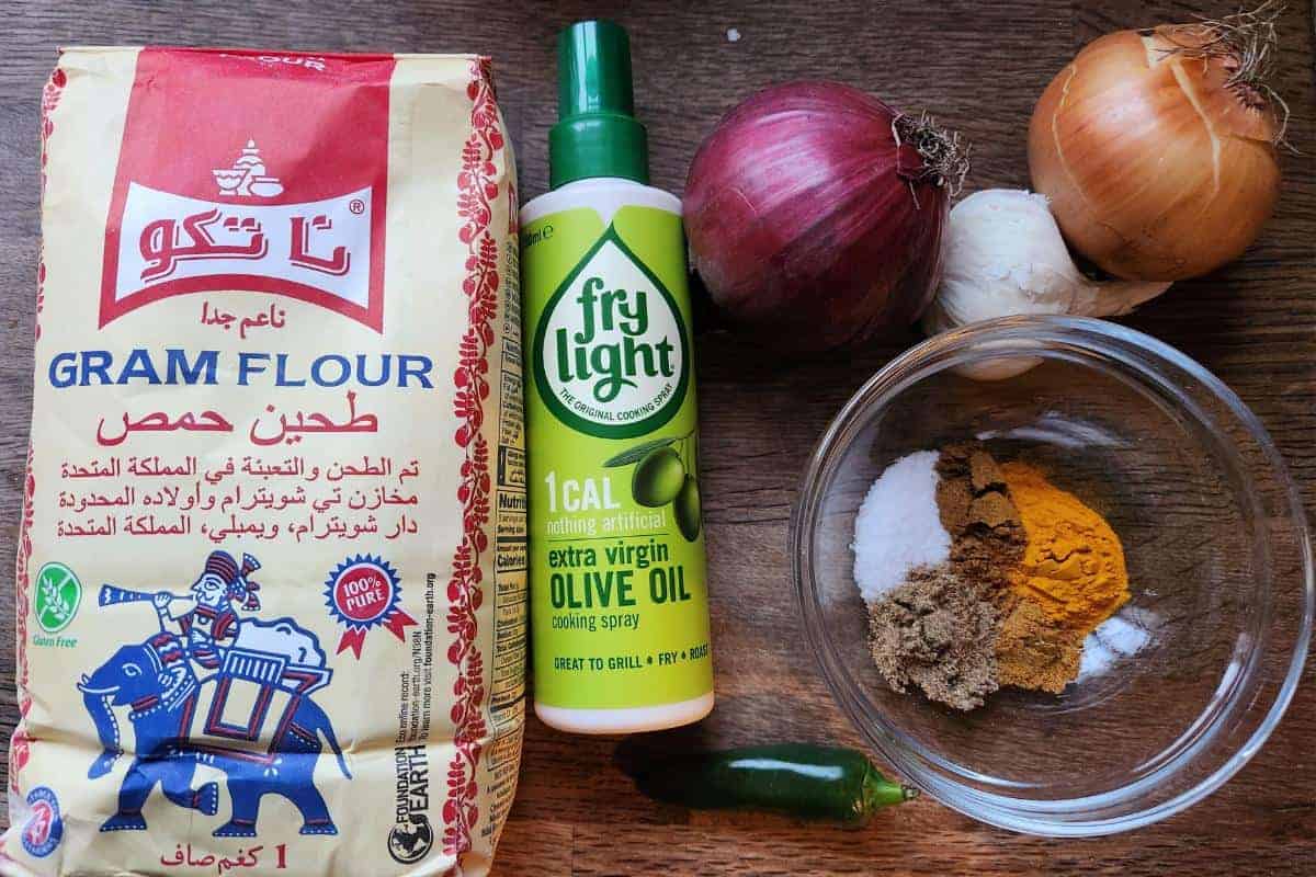 ingredients for air fryer onion bhajis laid out on wooden worktop