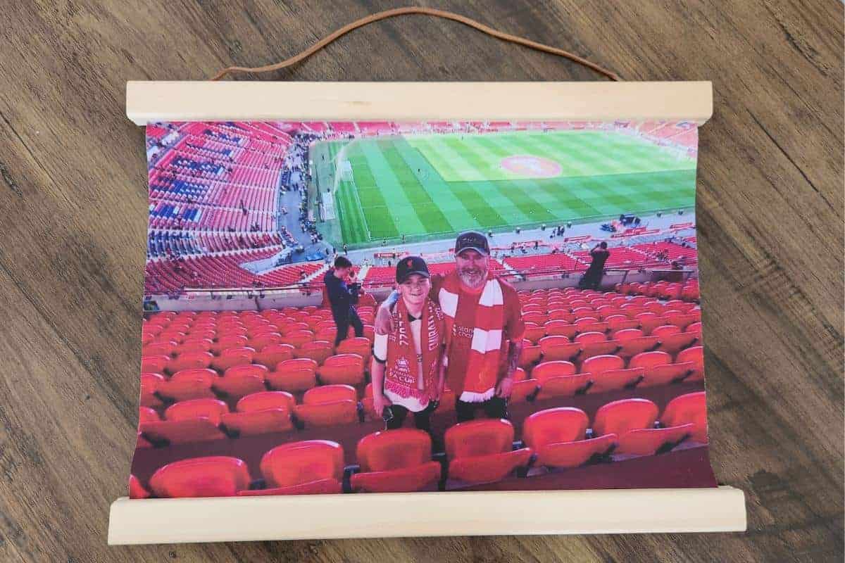 A father and son at Wembley wearing Liverpool FC supporters shirts and scarves excitedly waiting for the game.