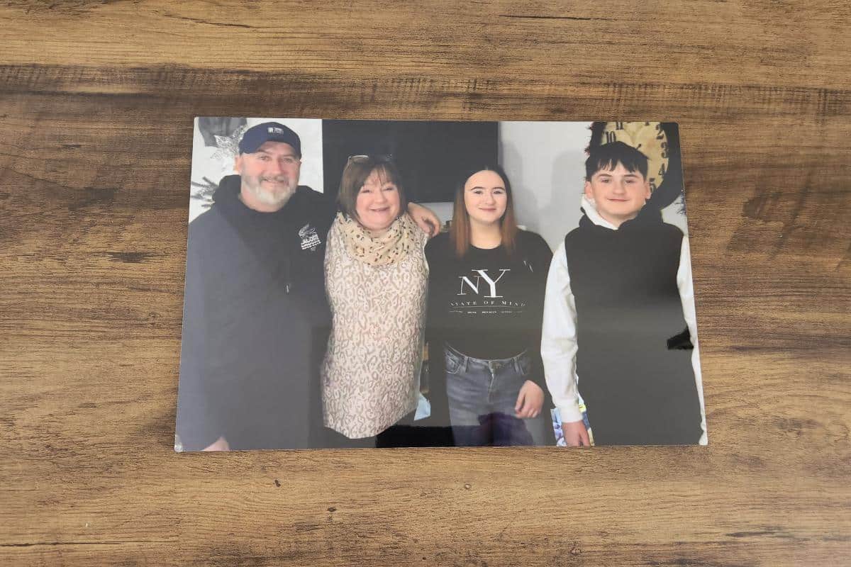 An aluminium print of a family with smiling parents and teenage children.