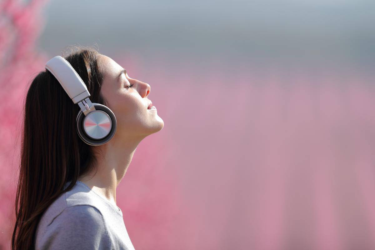 Lady listening to a book with headphones.