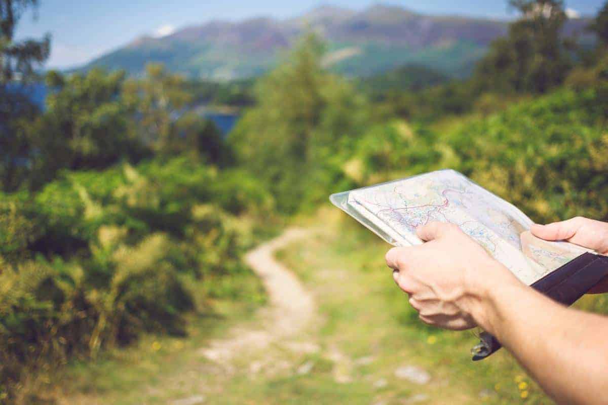 Man holding a map in the countryside.