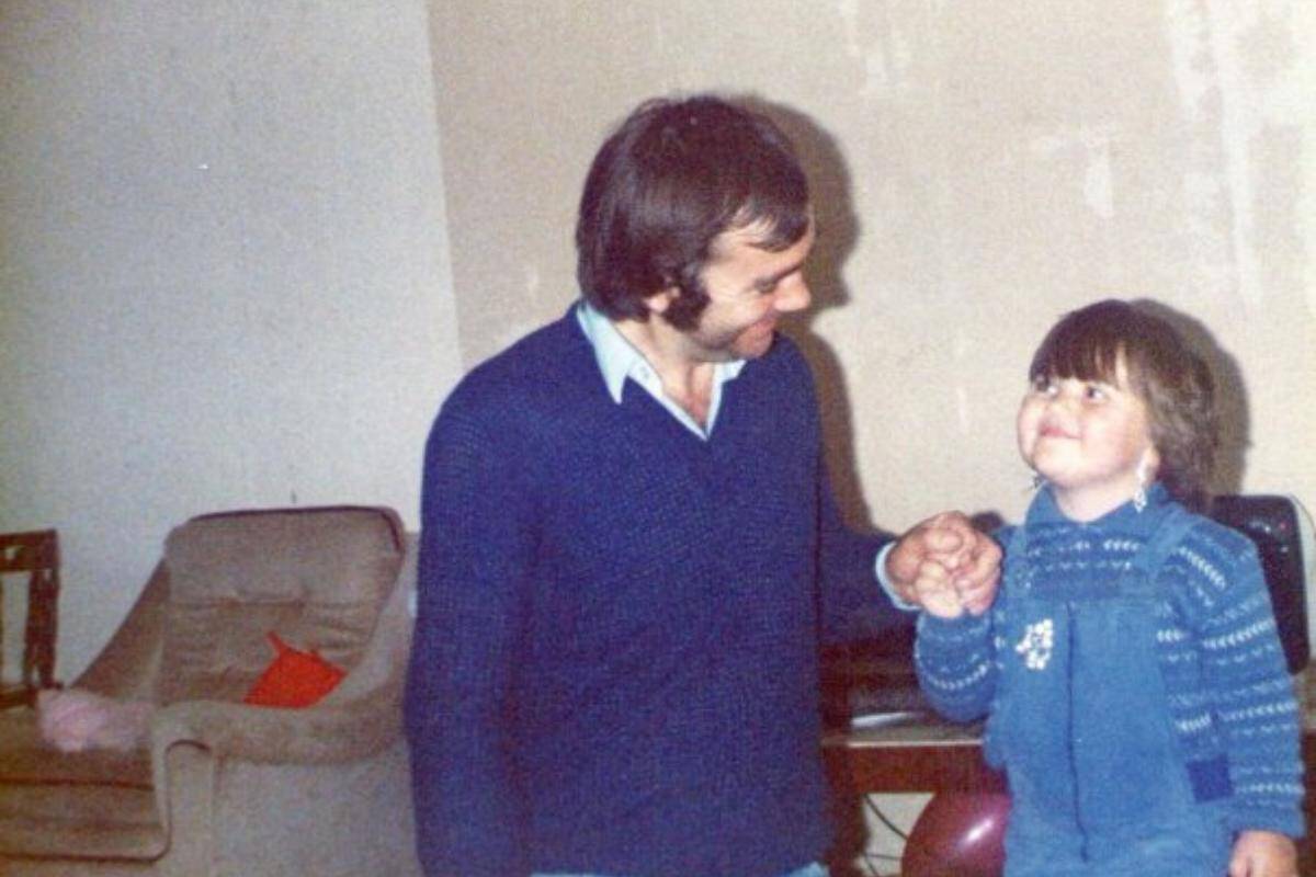 young girl looking up to her dad smiling in 80s clothes