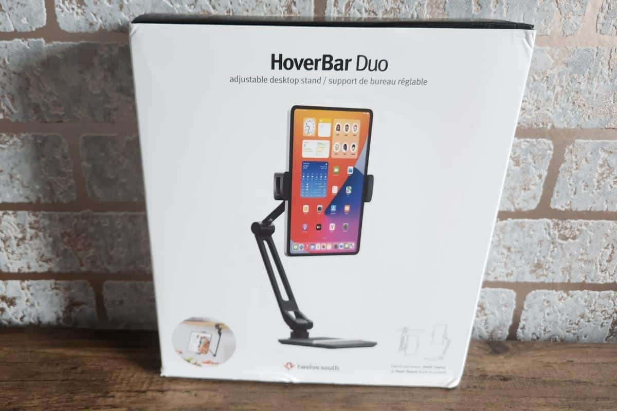 A boxed hover bar duo which is a clamp with an arm holding an ipad on a desk.