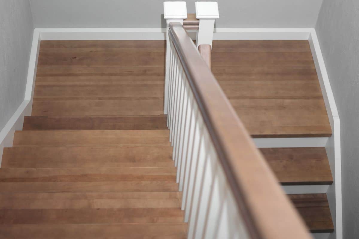 Wooden staircase with a white bannister.