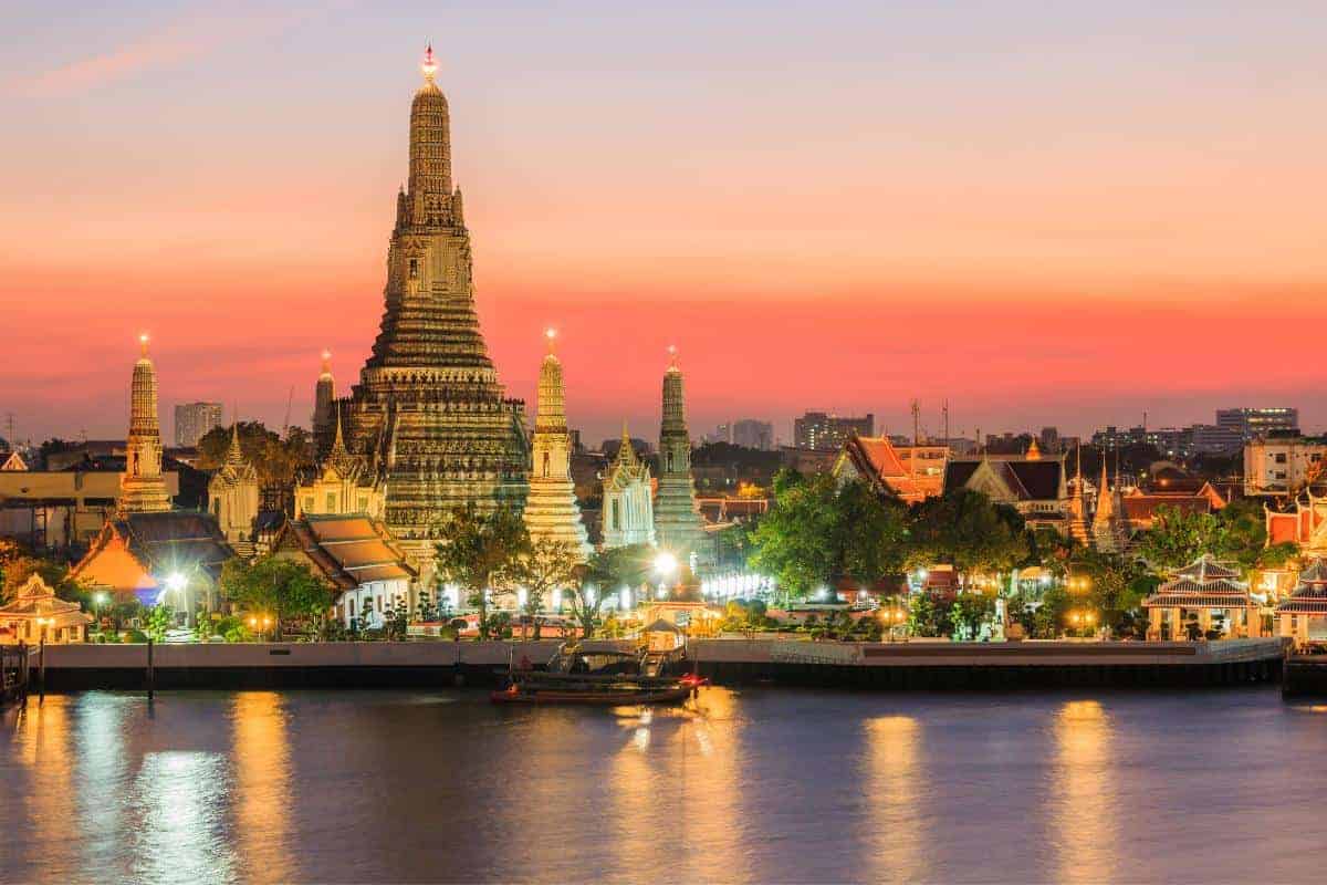 A nighttime image of temples and river in Thailand.