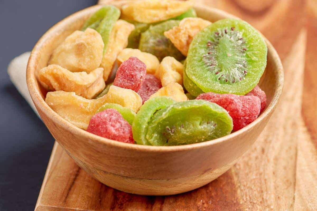 Dehydrated fruit in a wooden bowl with kiwi, raspberries and banana.