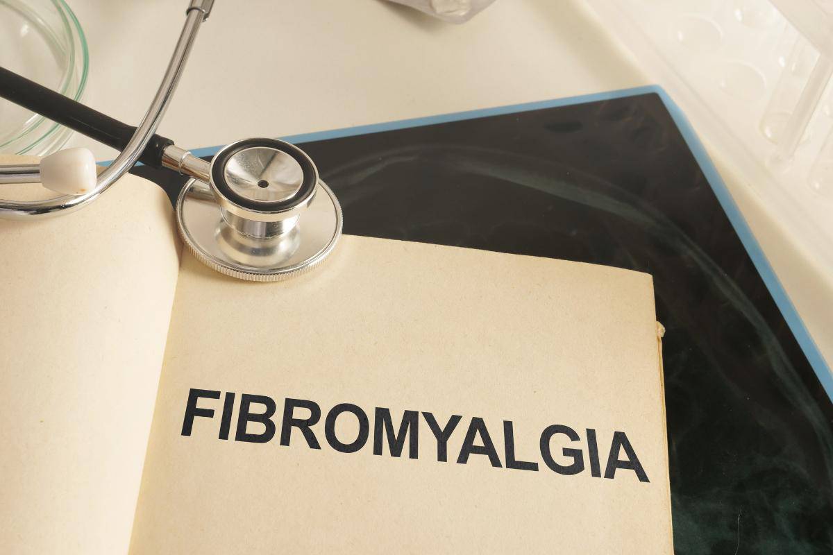 Printed word fibromyalgia with a doctors stethoscope next to it in a doctors office