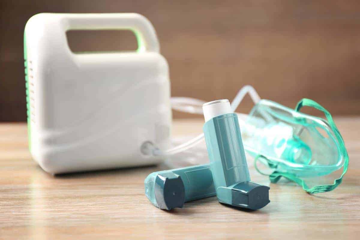 Blue inhalers next to a nebuliser for treating asthma and asthma attacks