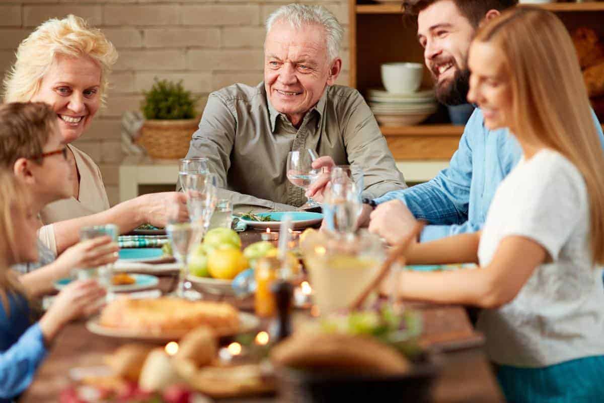 A family sitting eating and chatting around a dining table.